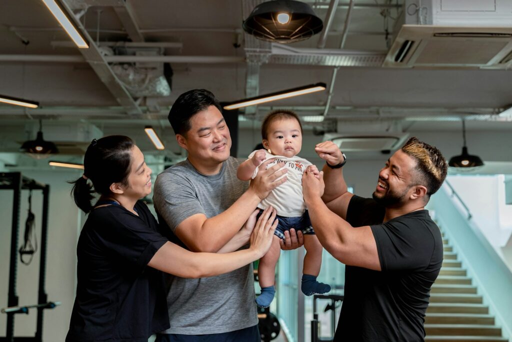 Family and trainer celebrate baby in the gym.